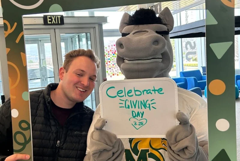 student and mascot holding a sign saying celebrate giving day Marywood Celebrates Record-Breaking Giving Day 2026